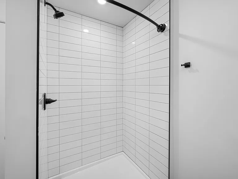 Elegant modern shower with sleek white subway tiles and contemporary black fixtures. Elegant modern shower with sleek white subway tiles and contemporary black fixtures.