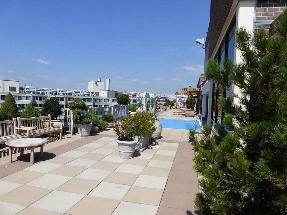 Building features a large landscaped rooftop with pool.