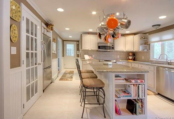 Fully equipped eat in kitchen complete with panty, pot rack stainless appliances and newer granite counter tops.