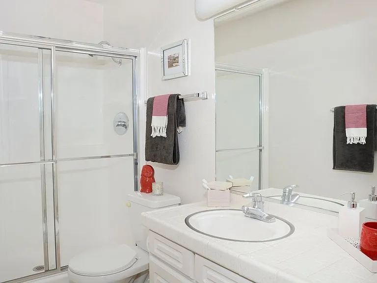 Classic Package bath featuring white tile countertops and white cabinetry