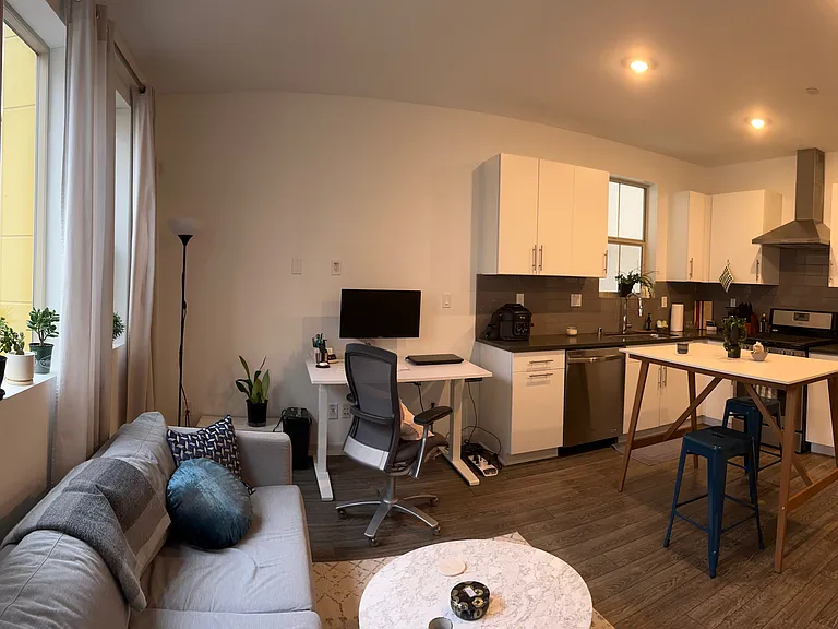 View from balcony door of living room area and kitchen space (decorated)