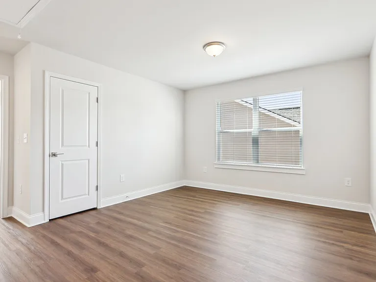 Bright room with a window and classic white door.