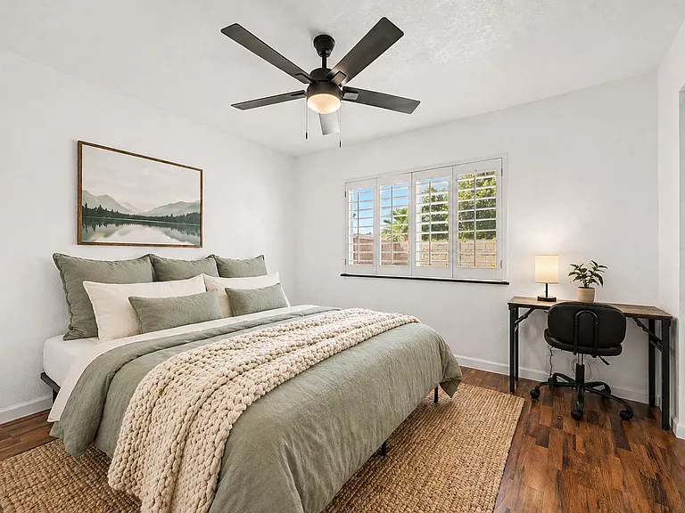 Wood flooring, Queen Bed, desk, chair, lamp, fan, mirrored closet.