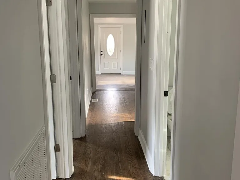 From the primary bedroom down the hallway, through the kitchen and living room, is the front door
