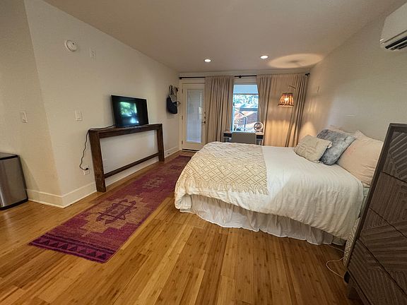 Studio space with lots of natural light, bamboo floors, full size bed, dresser, TV and desk.