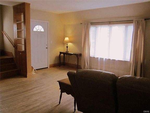 This is a view of the other side of the Greatroom with it's big picture window for lots of natural lighting, the neutral decor, and that's a NEW front door!