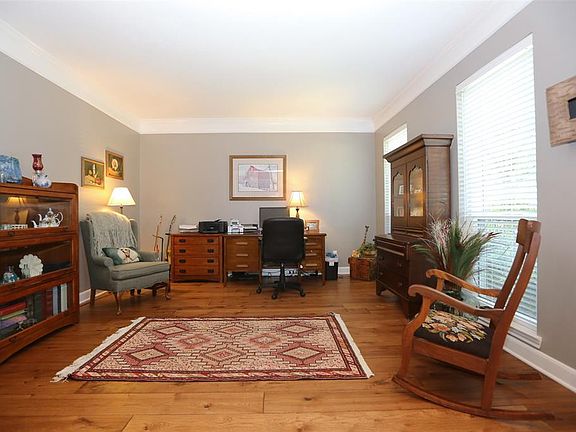 This formal living area has crown molding and great light, and is currently in use as a study.