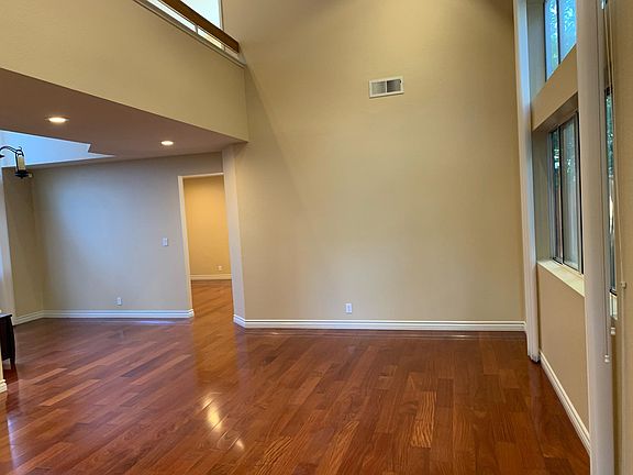 Living room with high ceiling and a separate dining area.