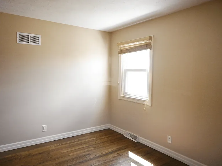 Bedroom with window in the corner at Square 131 5-Plex.