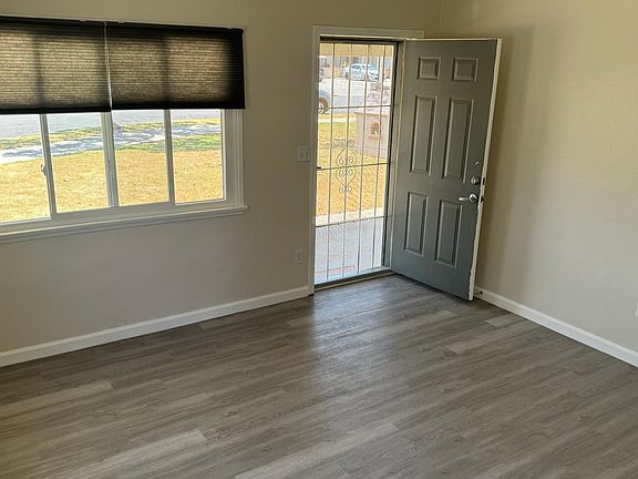 Living room looking out front door to covered patio and front yard.