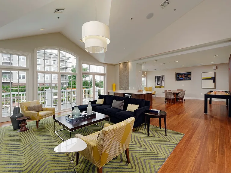Resident lounge with patio, kitchenette, common area seating and shuffleboard table
