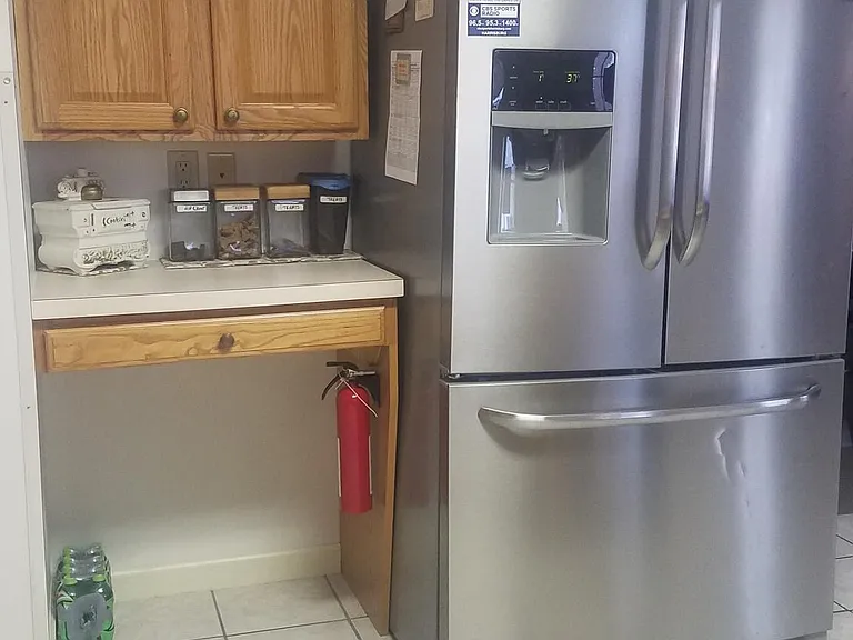 Oversized refrigerator with water and ice in the door; kitchen desk built in