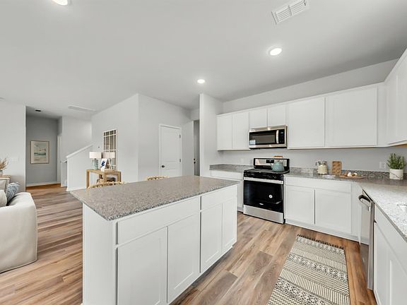 The oversize kitchen island provides exceptional granite countertop and cabinet space.