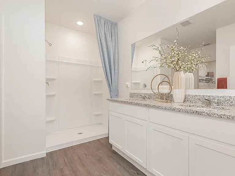Bright and elegant bathroom featuring a spacious walk-in shower, sleek granite countertops, and modern cabinetry.
