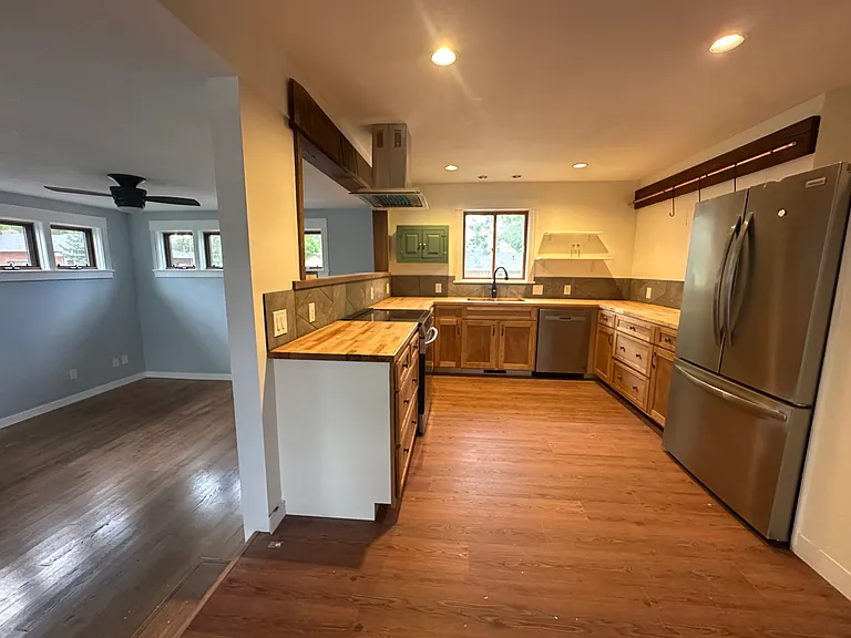Small step up to kitchen & dining area. New cabinets, dishwasher, induction stove, refrigerator, butcher block countertops
