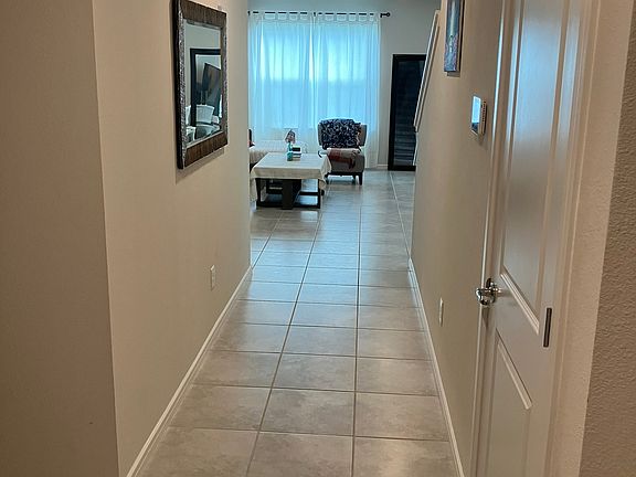 View from front door. Harry Potter-style closet to the right. Guest room, guest bath & door to garage on left hallway. Living room straight ahead.