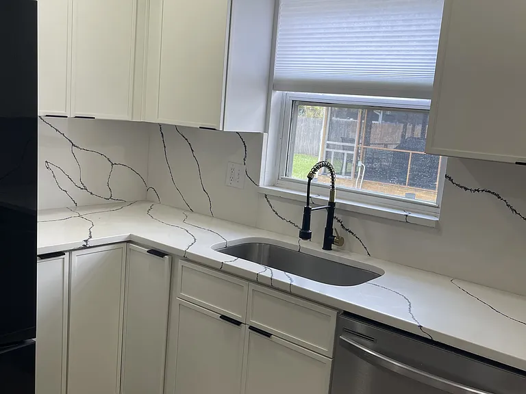 Left side of sink. High cabinets all over the kitchen.