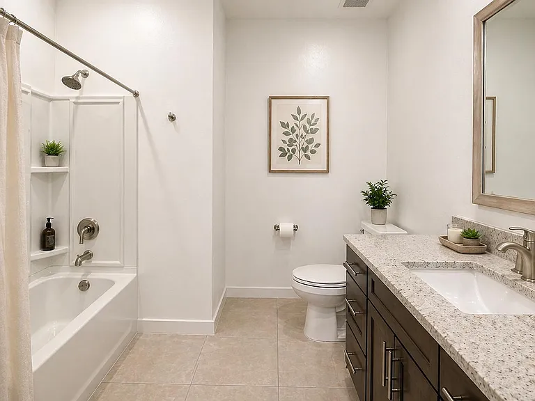 Full bathroom with tub/shower combo, tile flooring, and a long vanity with stone countertop and large framed mirror.
