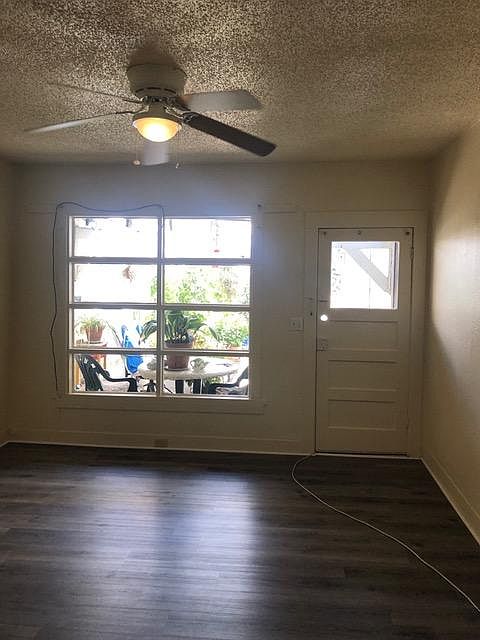 Bright living room with ceiling fan and private entrance.