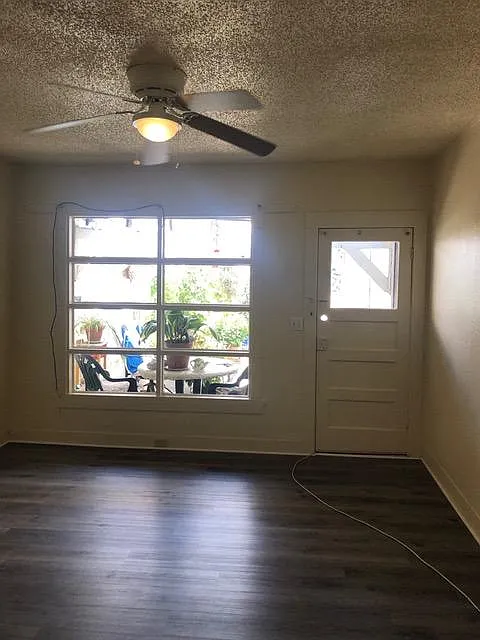 Bright living room with ceiling fan and private entrance.