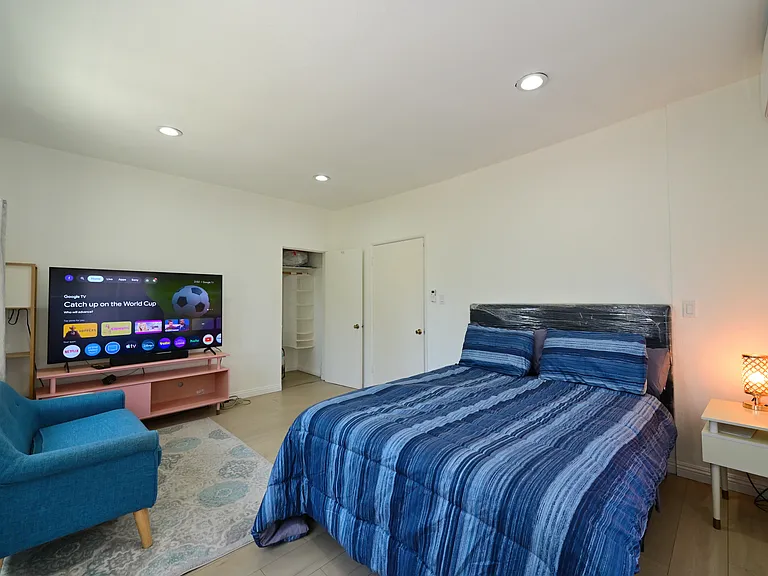 Super spacious bedroom furnished with TV, queen bed and mattress, mini split AC, Loveseat and Coffee table - with views of PCC