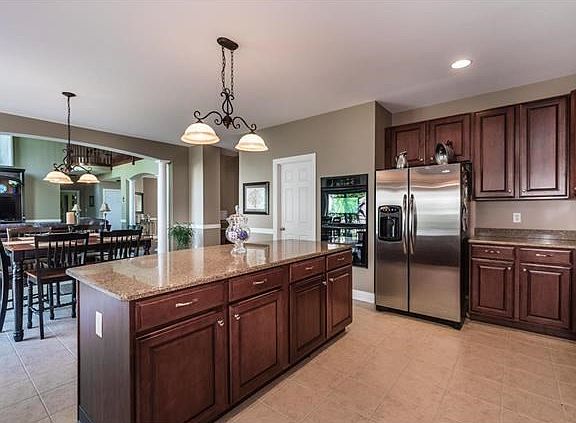 Oversized kitchen & breakfast room accented by an arch & columns. Ceramic tile floors, granite counter-tops, double ovens, and walk-in pantry are only a few of the perks of this impressive kitchen.