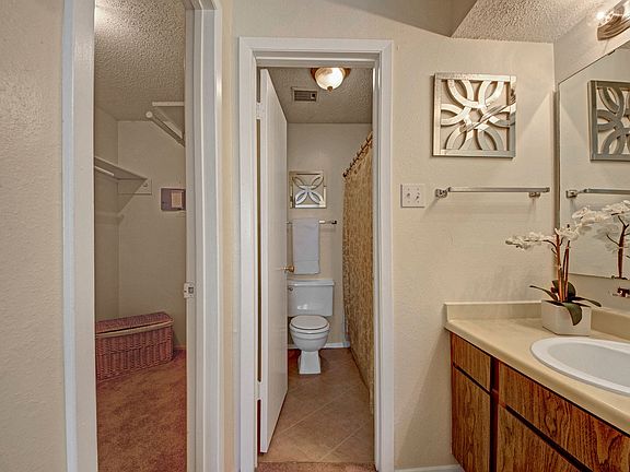 A bathroom next to a walk in closet for the master bedroom