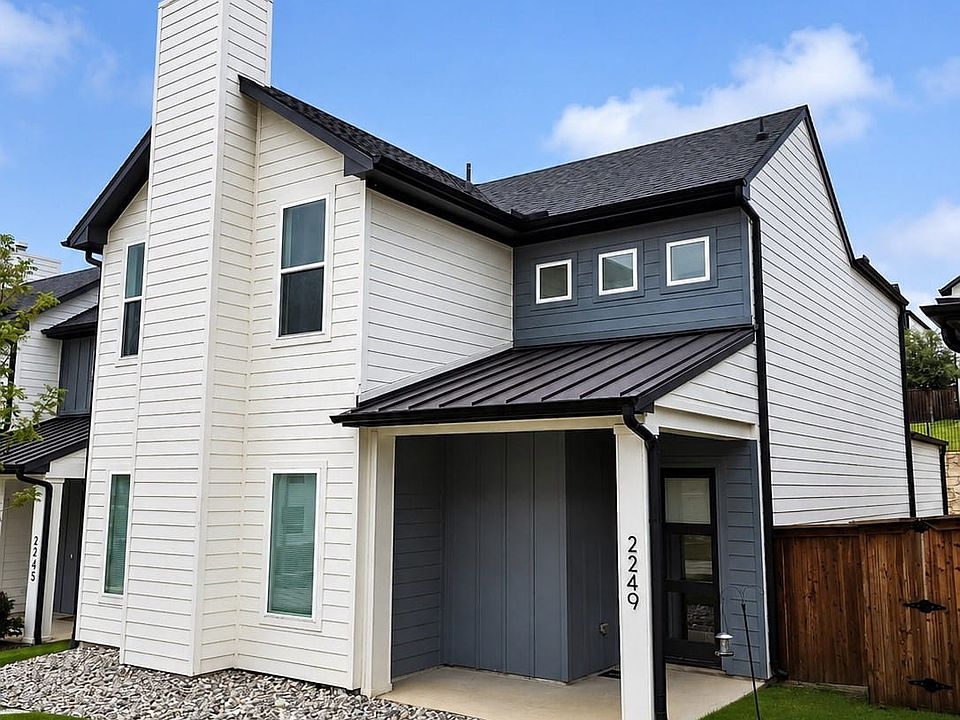Modern exterior featuring white and gray horizontal siding, a black metal roof, and a covered entry