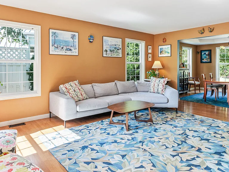 The warm and gracious living room is flooded with natural light, and opens on to the dining room.