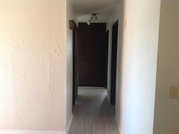 Hallway leading to bedrooms and view of spacious storage