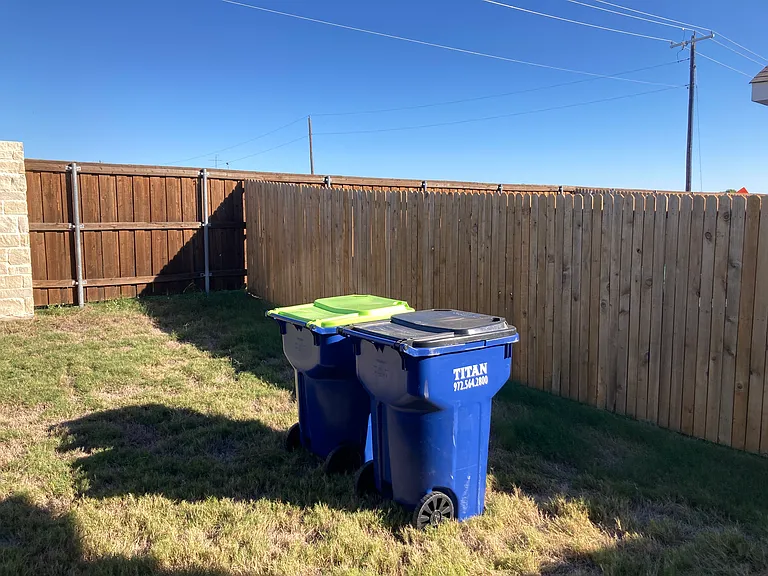 Trash cans kept in back yard.