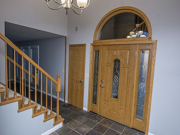 Foyer features large vaulted ceilings and tile floors.