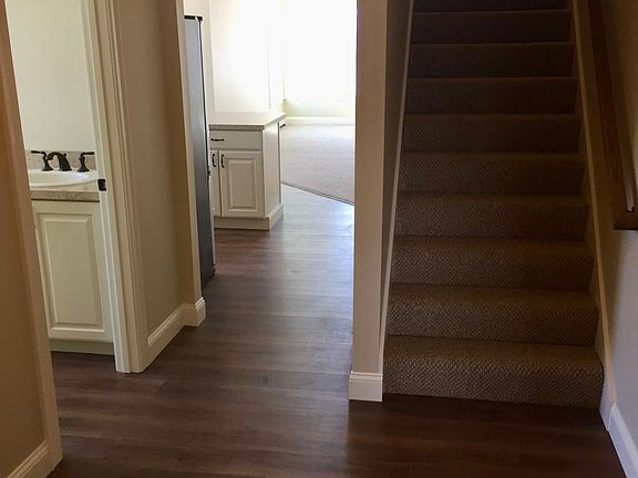 View from entrance. Storage room on the left followed by laundry then bathroom. Stairs lead to bedrooms on second level.