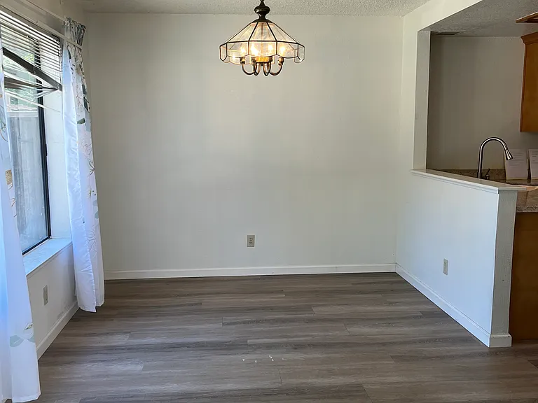 Dining room next to kitchen overlooking backyard