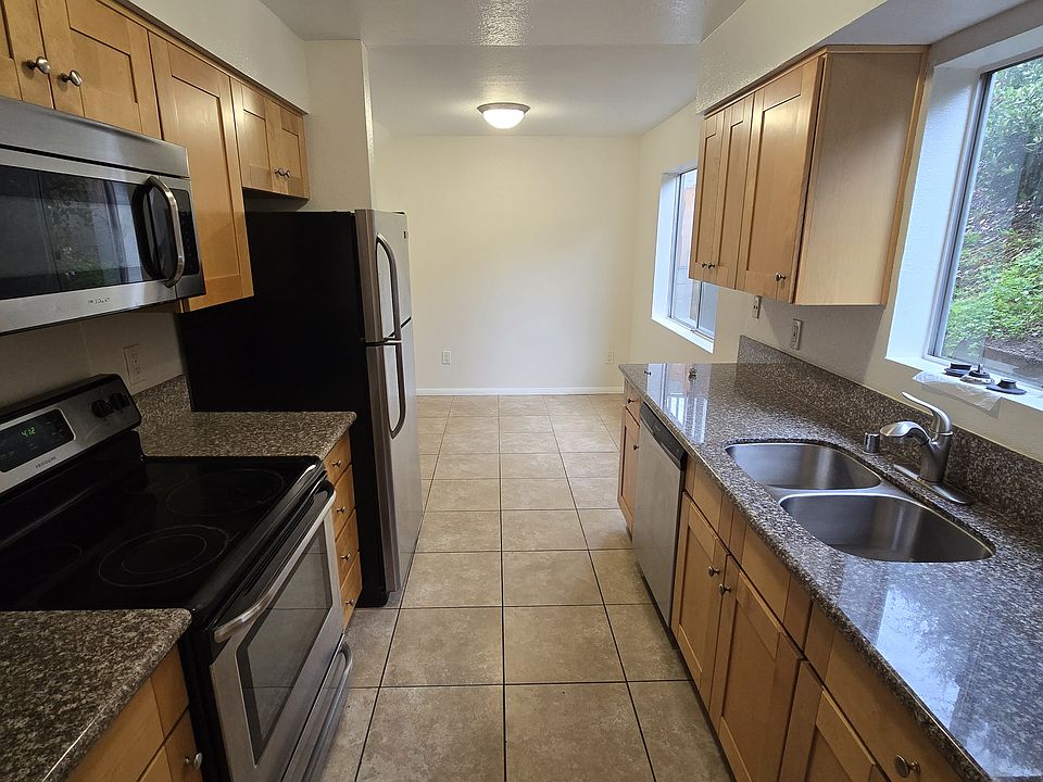 Kitchen opens to dining and living room, comes equipped with stainless steel appliances, including dishwasher, stove, oven and microwave.