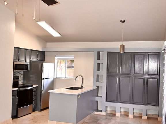 View of the Kitchen from the Living Room - Modern ceiling fan and dimmable cable lights