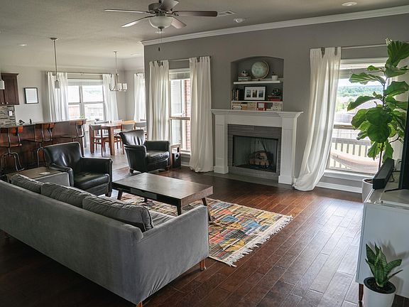 Open living area with south-facing windows, high ceilings, gas fireplace, and laminate floors (tile in kitchen and dining area).