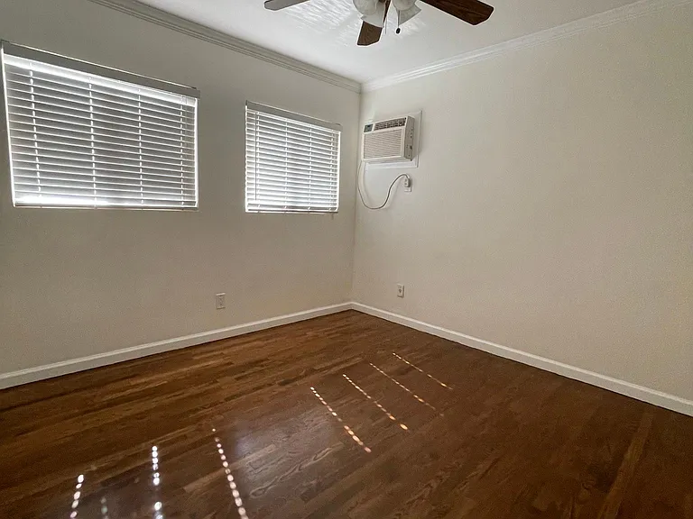 Light and bright bedroom with ceiling fan a/c/ and heat wall unit
