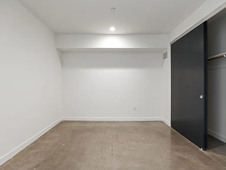 Bedroom with Recessed Lighting, Polished Concrete Flooring, and Closet