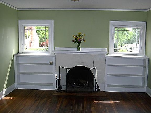 Livingroom is bright with built in shelves and a working fireplace.
