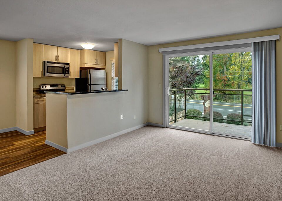 A cozy living space with a view into the kitchen and dining area