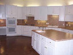 Spacious kitchen boasts island with sink, double ovens, and more