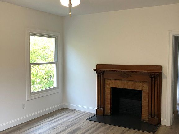 Spacious and sunny primary bedroom with decorative fireplace