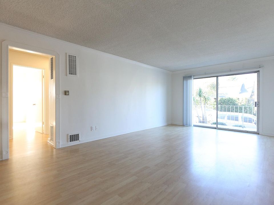 Living room w/ balcony facing Raymond Ave.