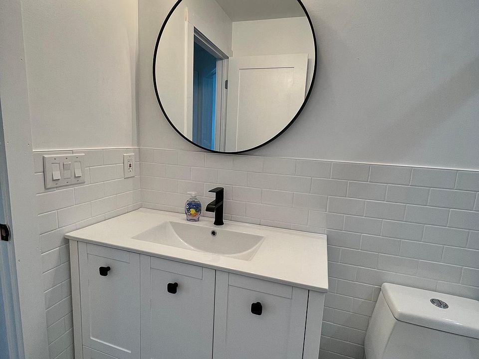 Vanity in the bathroom with half tile wall throughout.