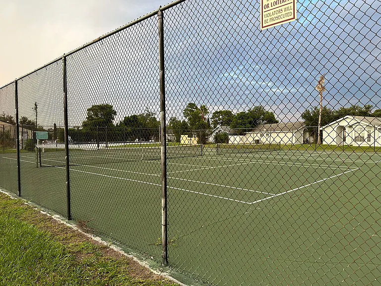 TENNIS COURT BY SWIMMING POOL.
