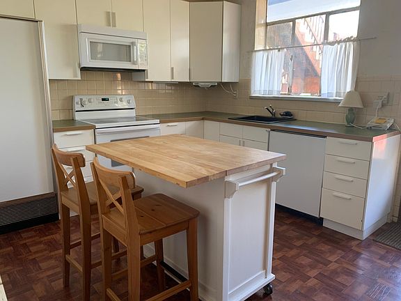 Kitchen with ikea cabinets and countertops, subzero fridge and freezer, movable butcher block island