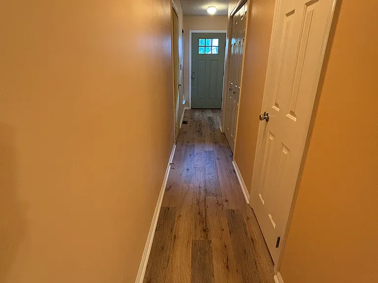Hallway has a coat closet, a door to the garage, and 1/2 bath