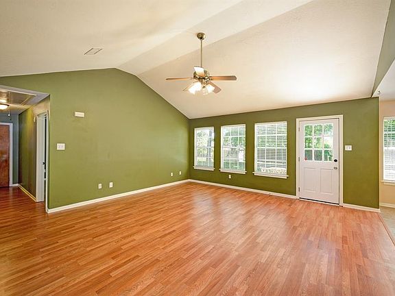 Spacious family room with vaulted ceiling and laminate flooring.