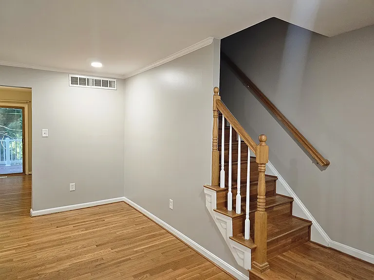 Stairway to upper level near front door entrance (in living room)